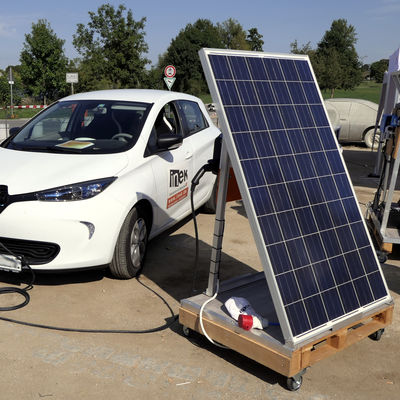 Ein Elektroauto, das an einer Photovoltaikanlage aufgeladen wird.